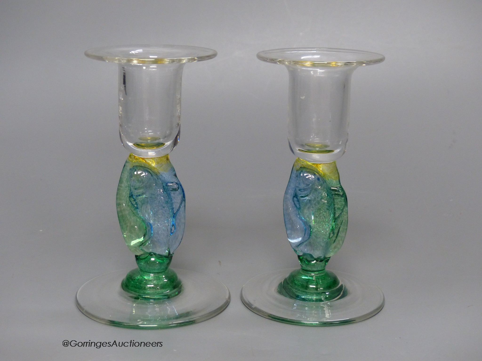 A pair of clear and coloured glass candlesticks by Helen Millard